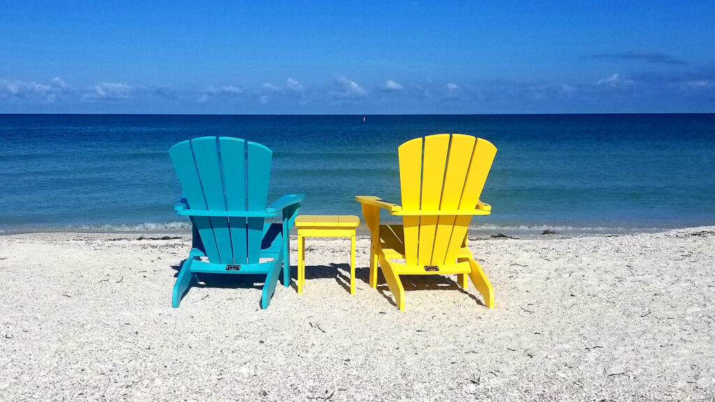 Blue and Yellow Adirondack Chairs on Beach